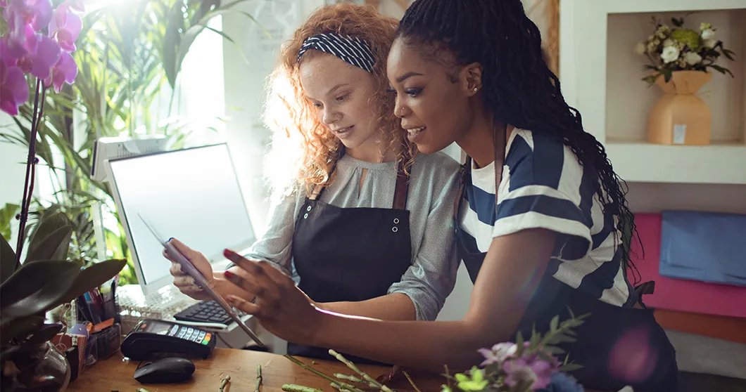 Zwei junge Frauen, die gemeinsam am Computer etwas überprüfen
